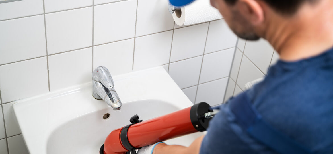 Plumber Cleaning Drain And Bathroom Sink Using Pump